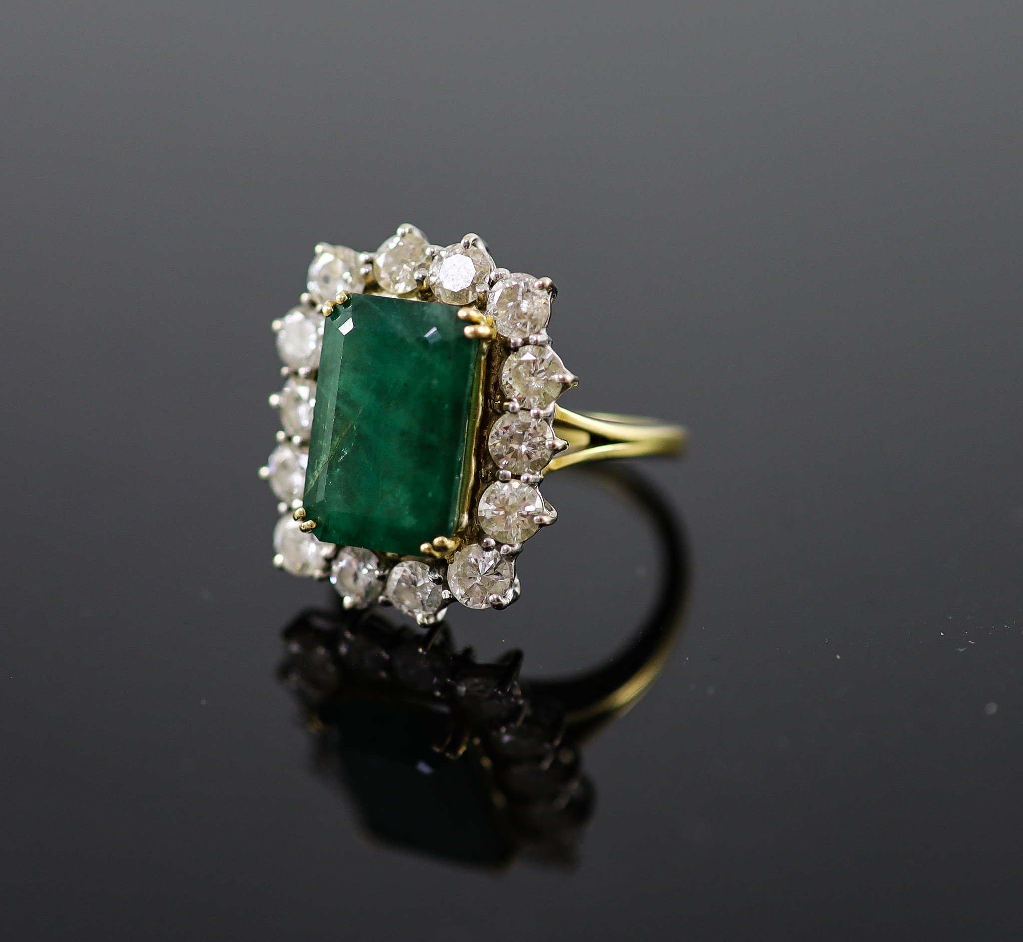 A mid to late 20th century 18ct gold, emerald and diamond set shaped rectangular cluster ring